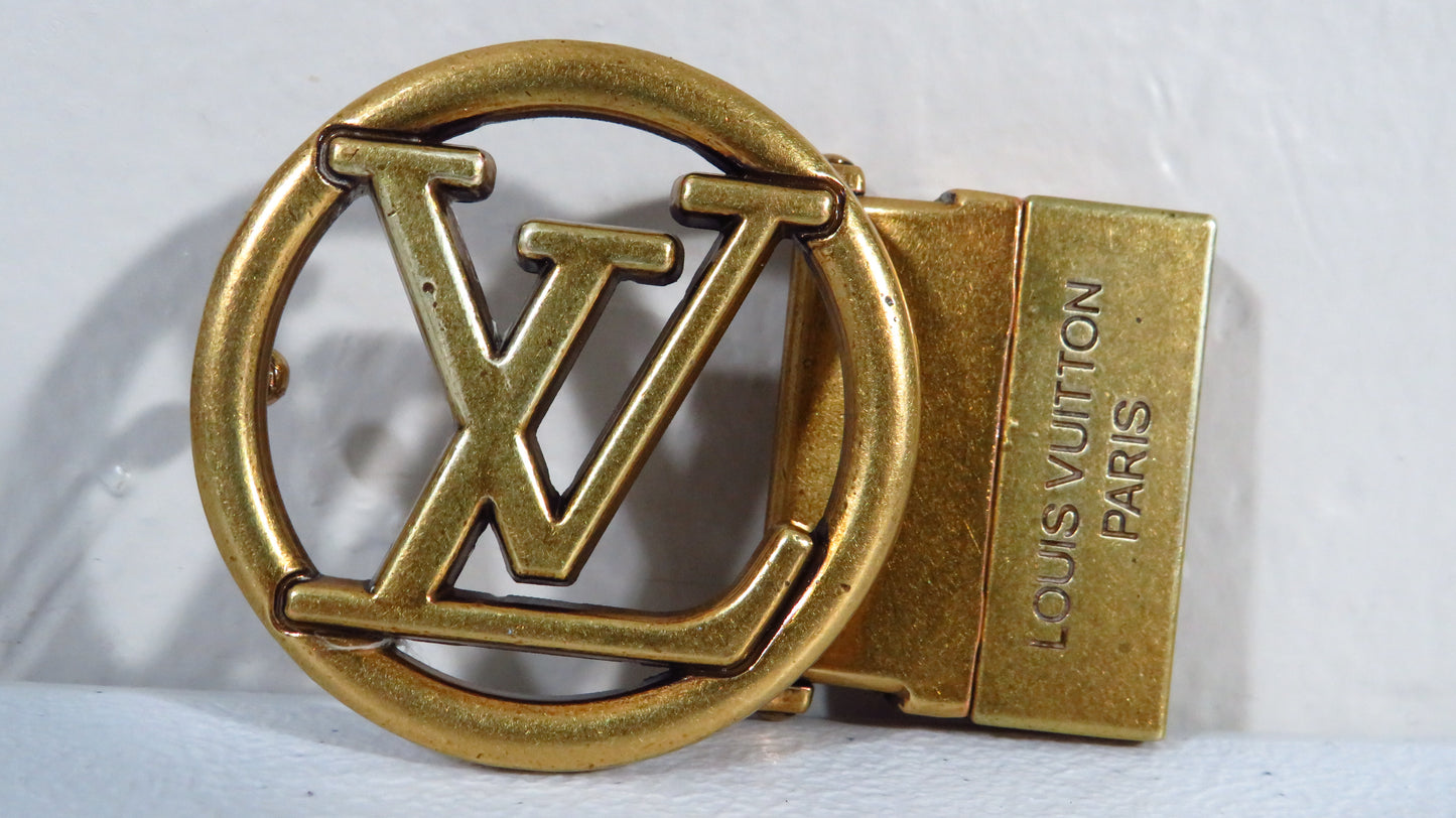 Gold belt buckle with Louis Vuitton logo on a white background
