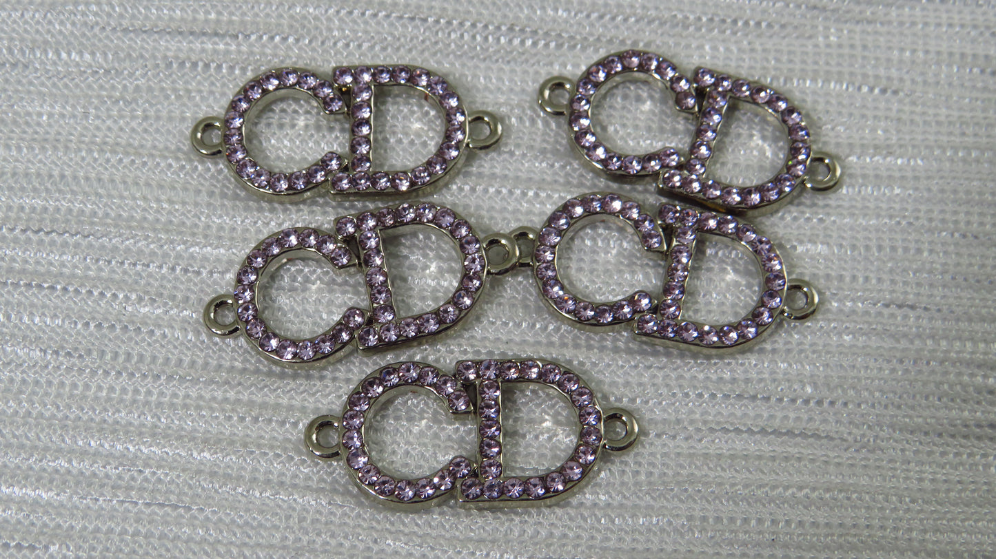 Purple and silver jewelry connectors on a textured gray background