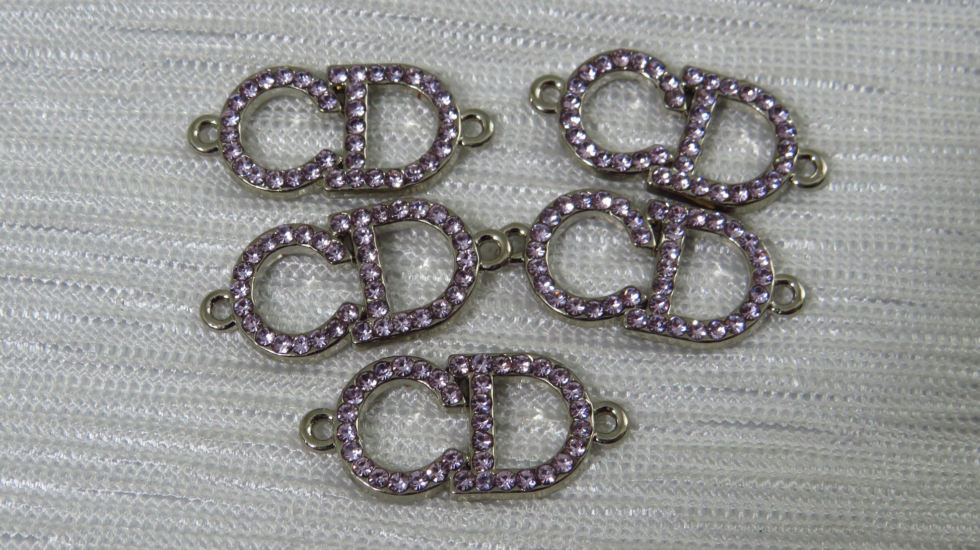 Purple and silver jewelry connectors on a textured gray background