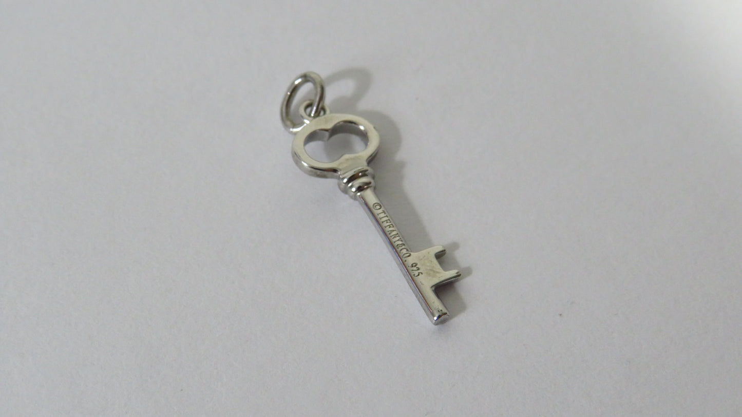 Silver key-shaped pendant on a white background