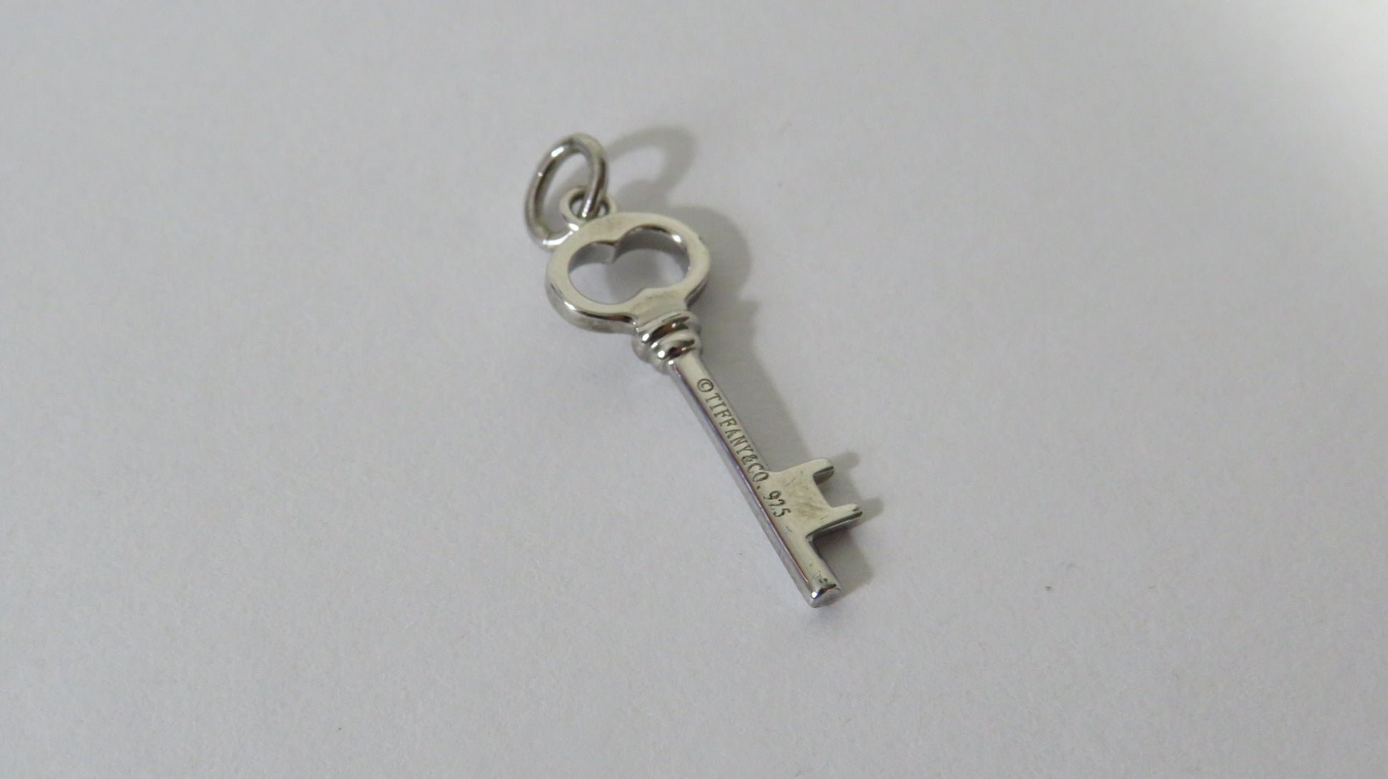 Silver key-shaped pendant on a white background