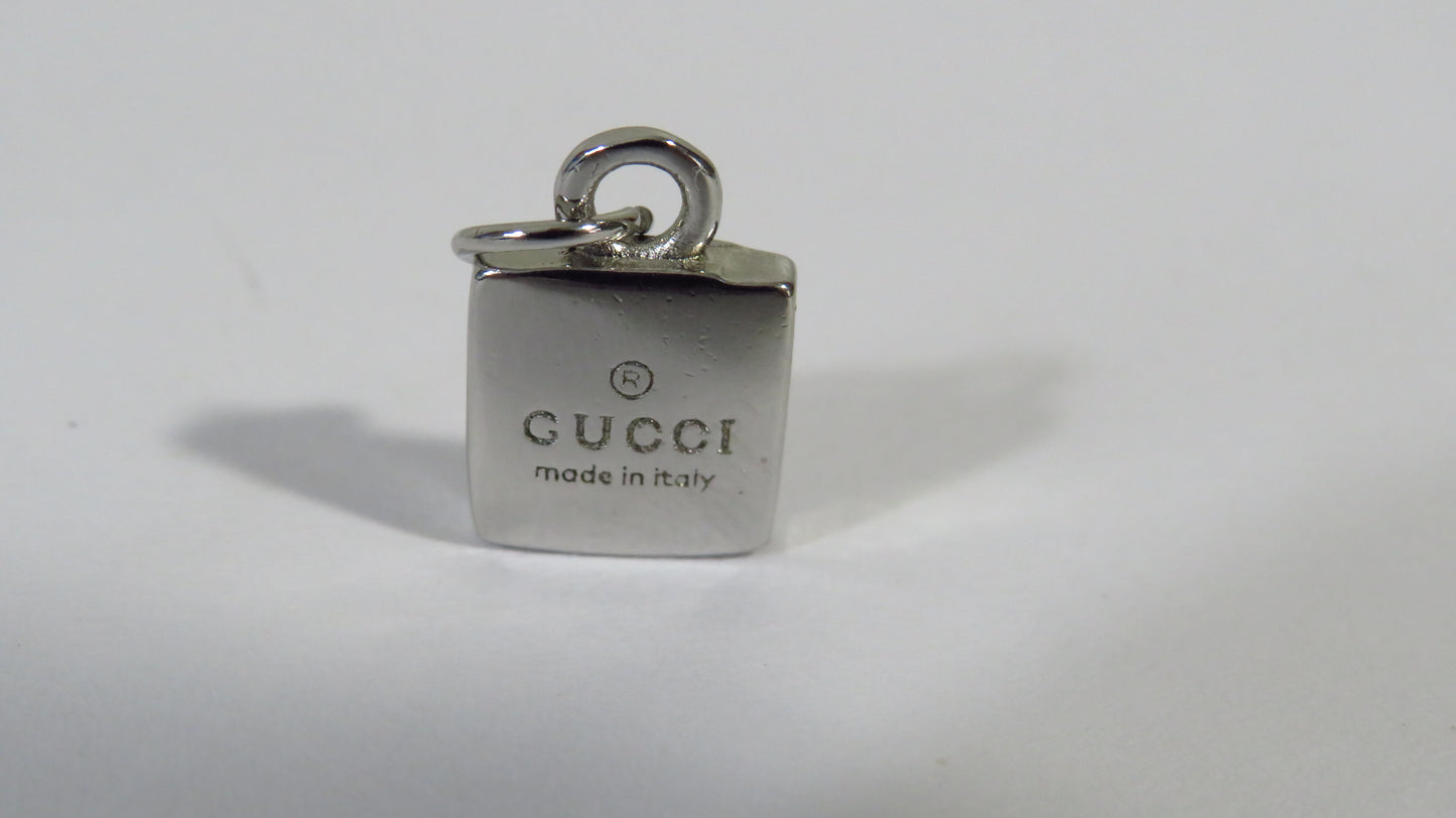 Gucci charm with 'made in Italy' text on a white background