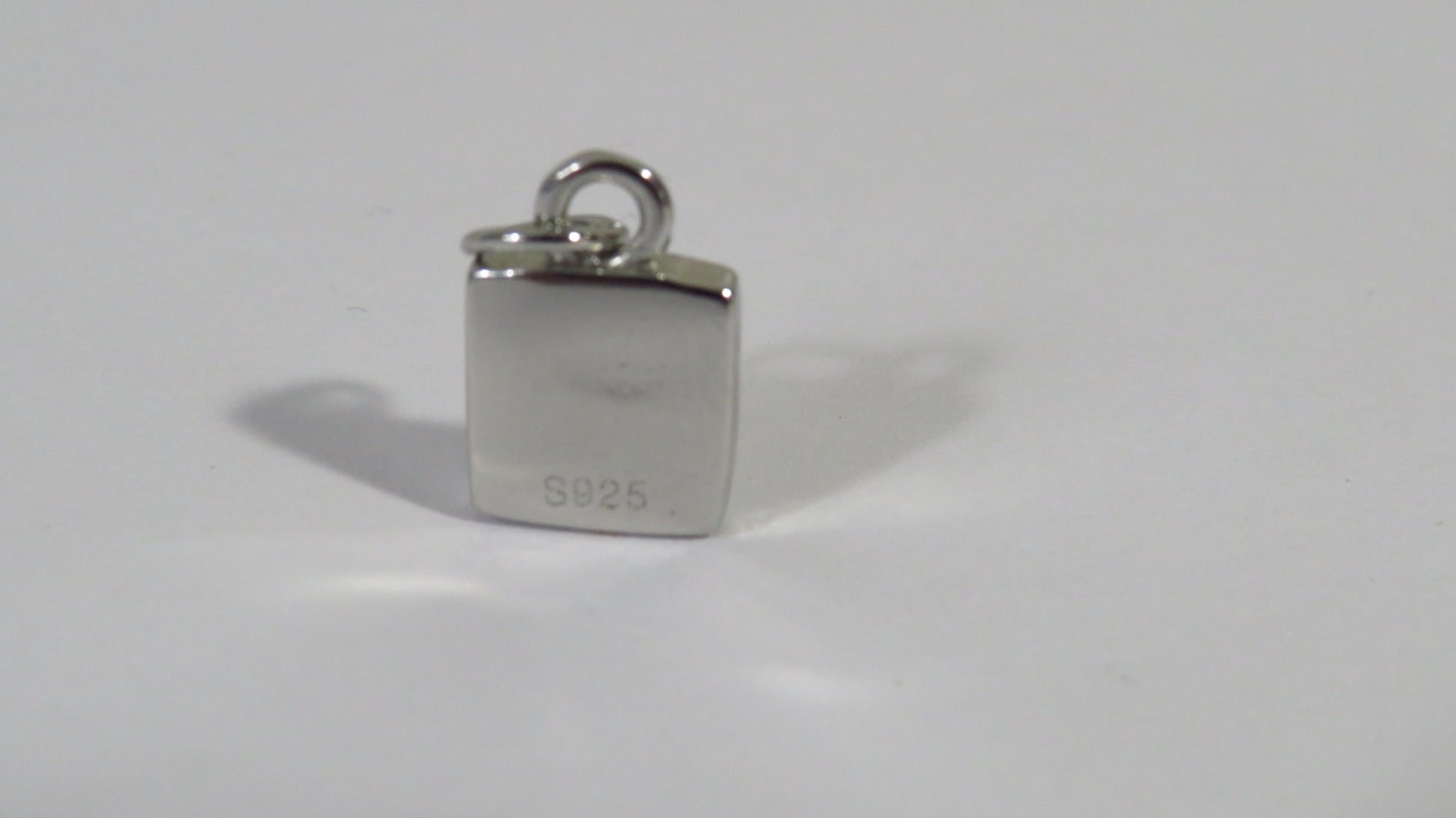 Silver pendant with '925' stamp on a white background