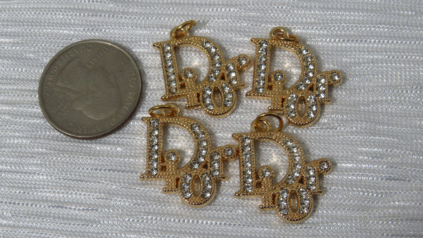 Gold Dior charms next to a coin!