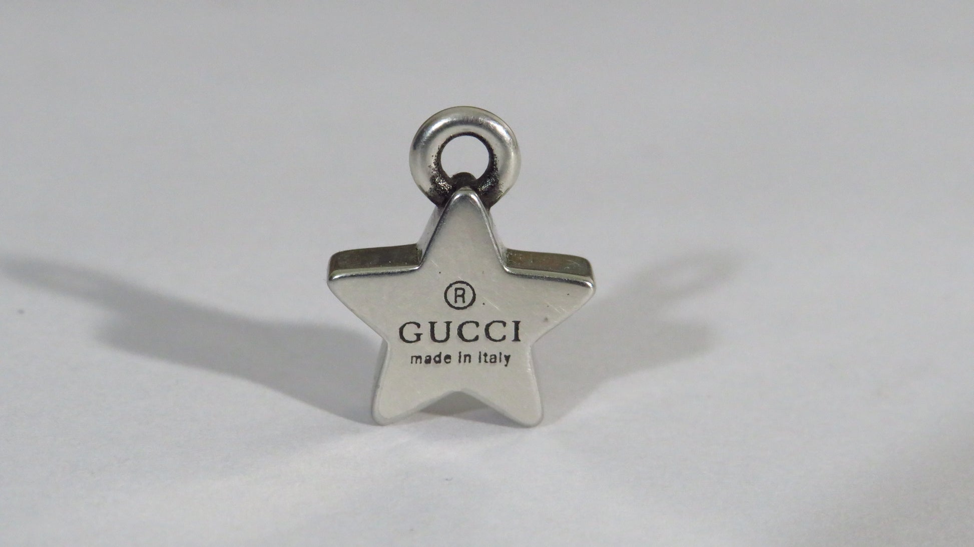 Star-shaped Gucci charm on a white background