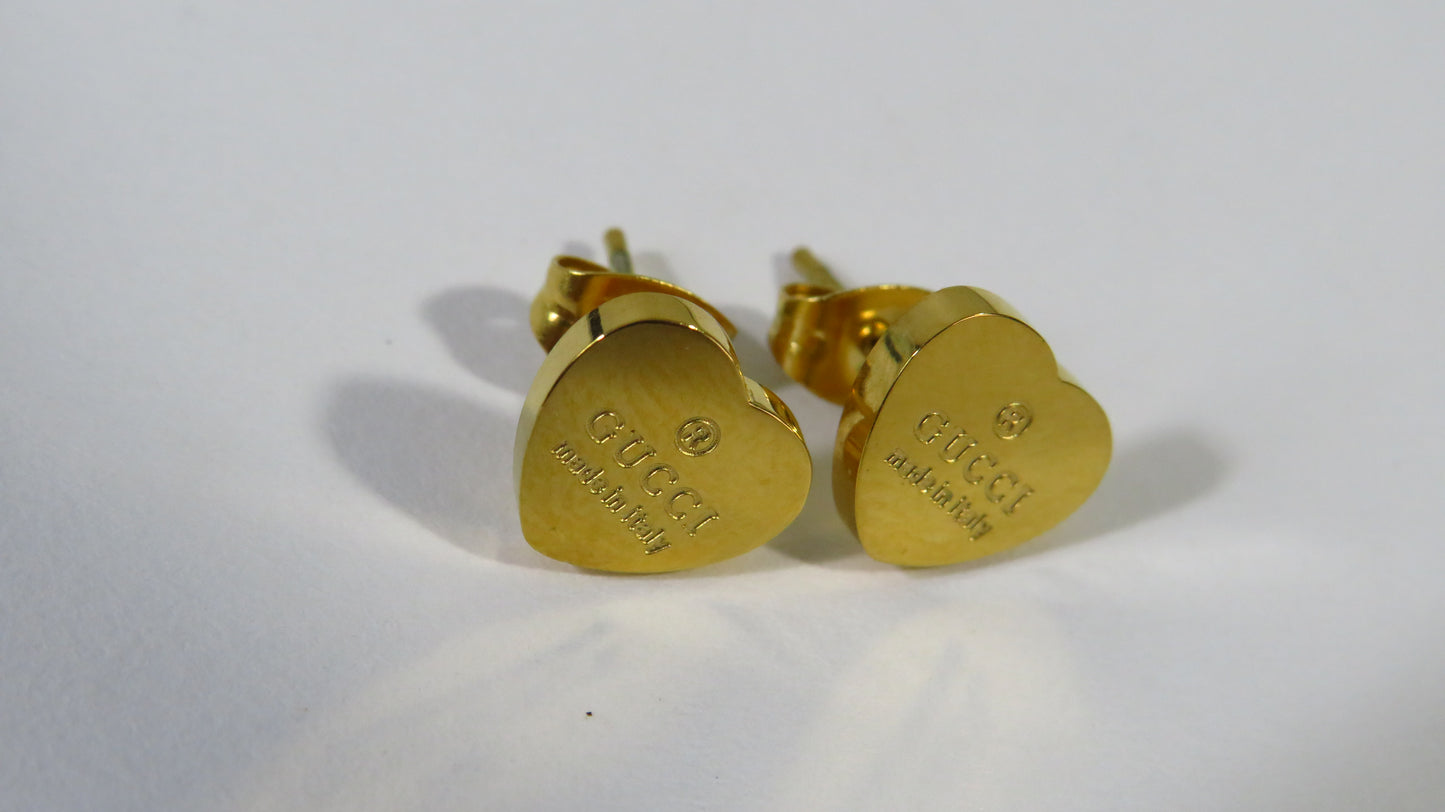 Gold heart-shaped earrings on a white background