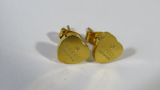 Gold heart-shaped earrings on a white background