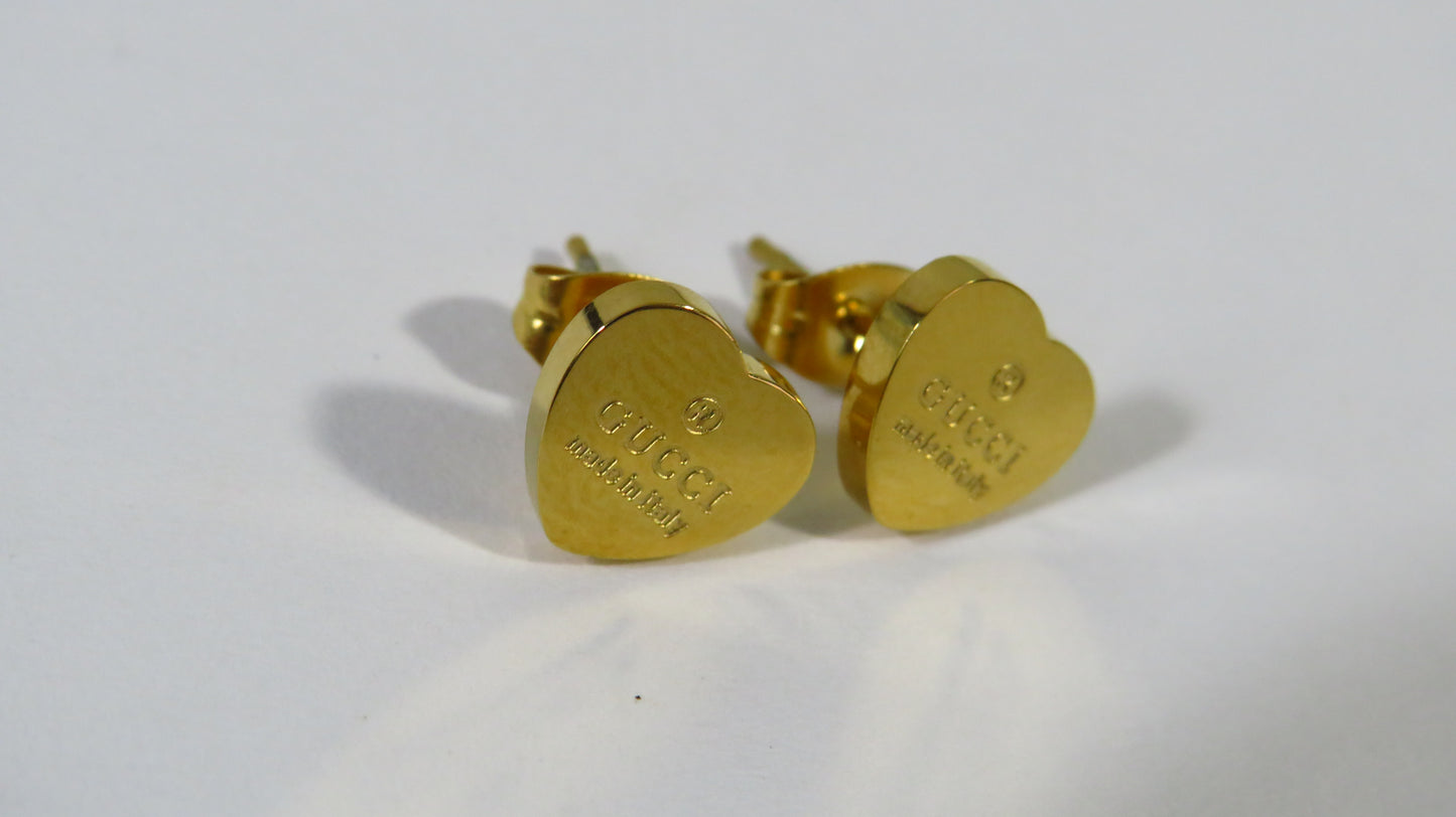 Gold heart-shaped earrings on a white background