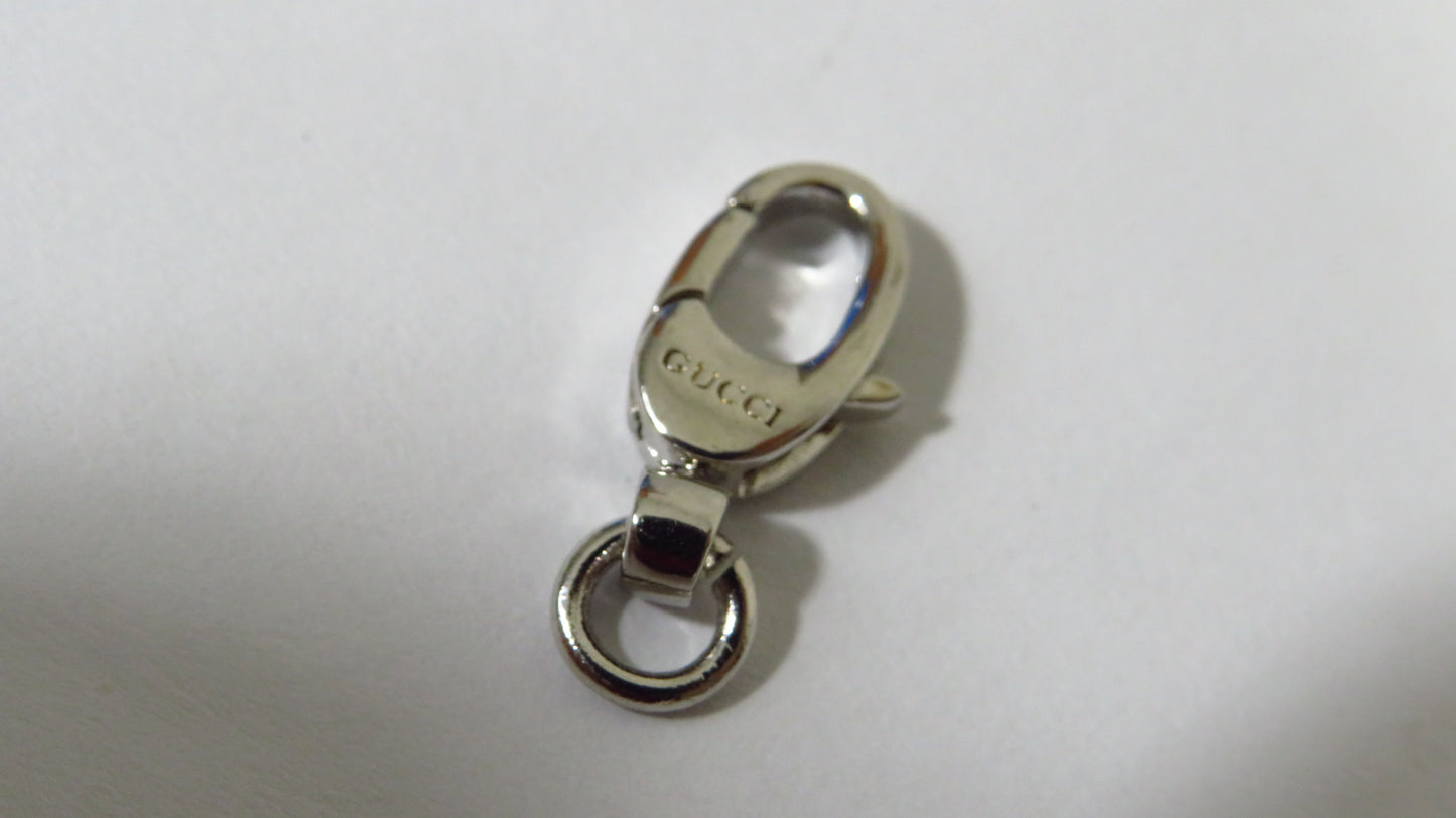 Silver Gucci clasp on a white background