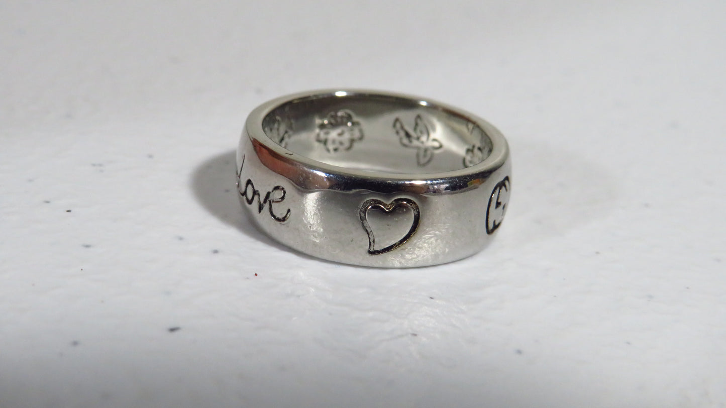Silver ring with engraved designs on a white background