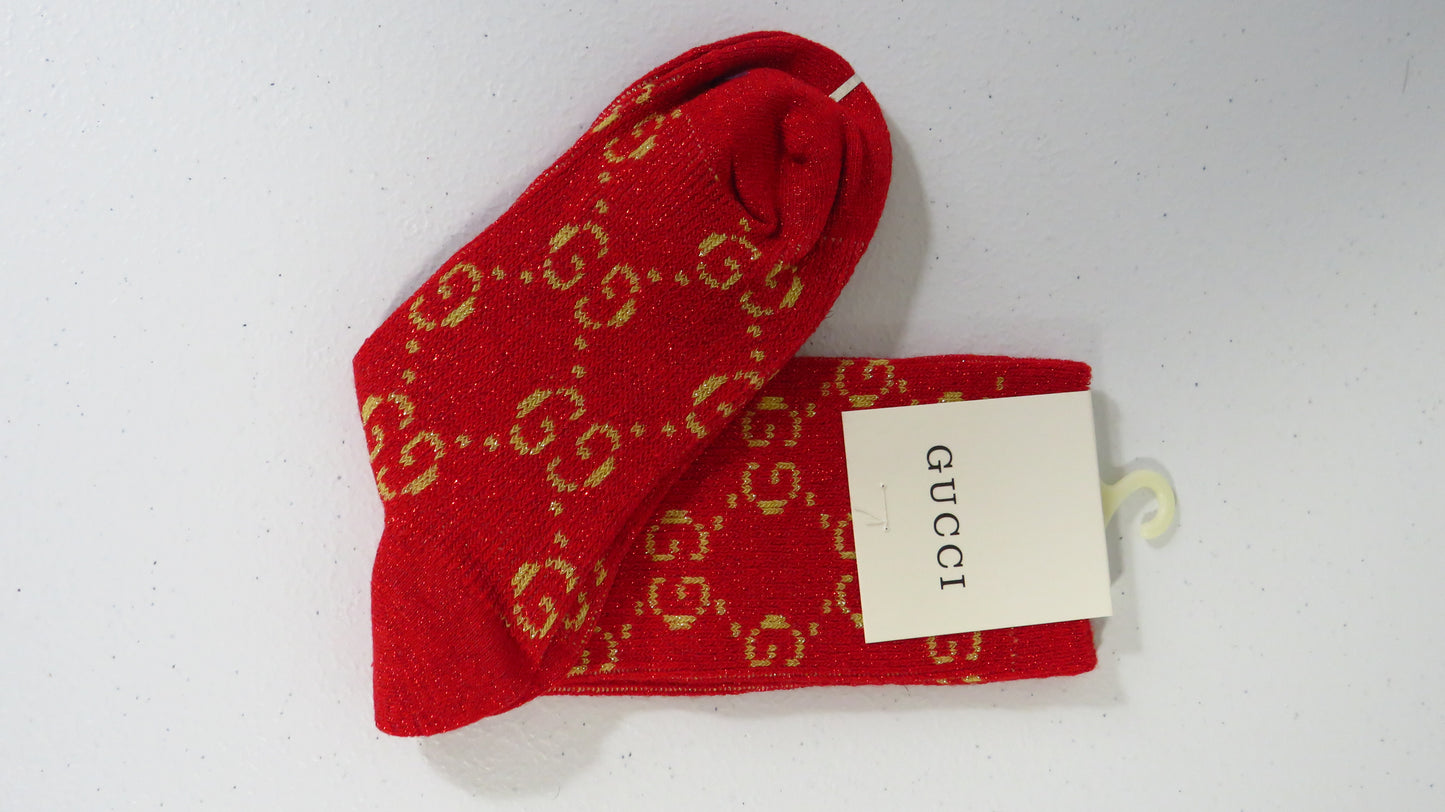 Red Gucci socks with a gold logo on a white background