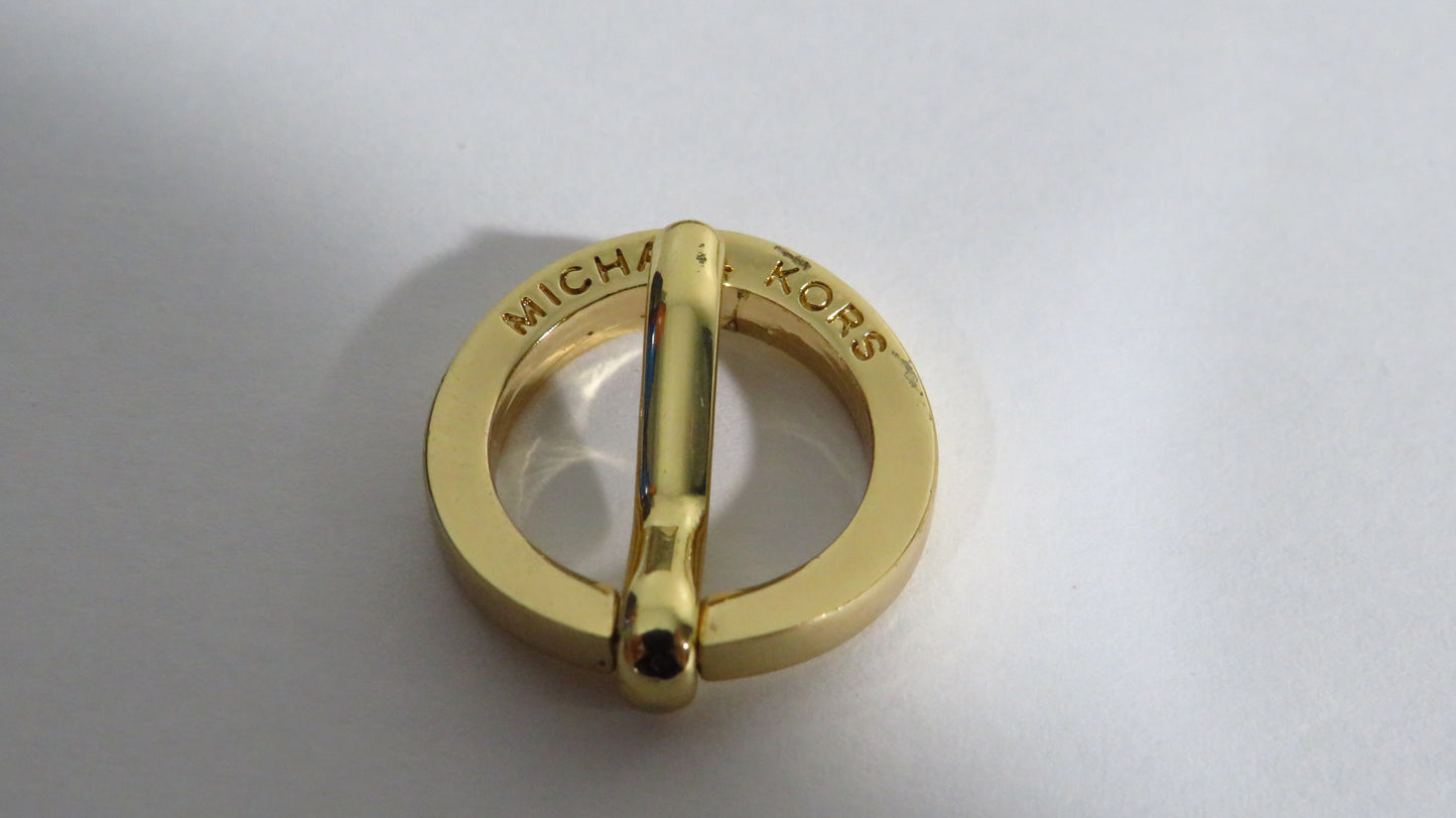 Gold ring with 'Michael Kors' engraving on a light gray background